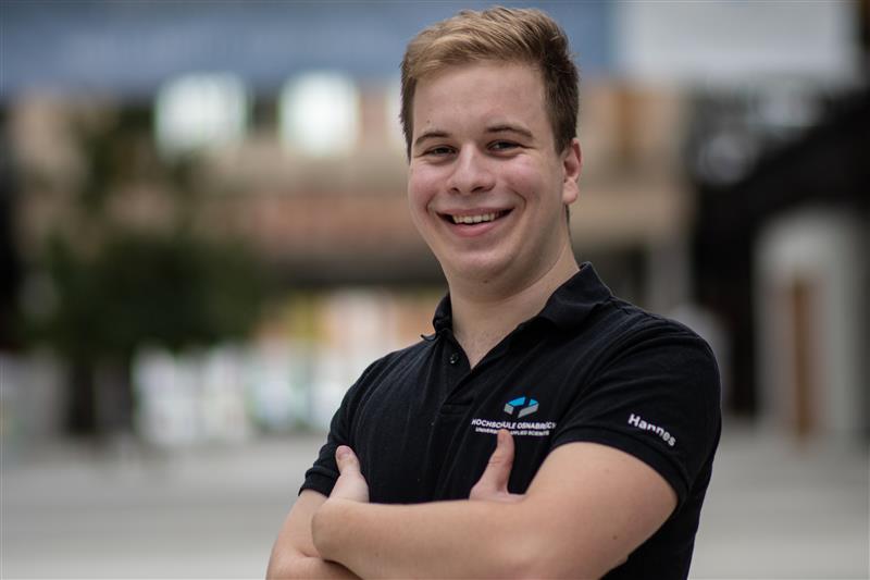Hannes Cerny lächelt mit verschränkten Armen in die Kamera.