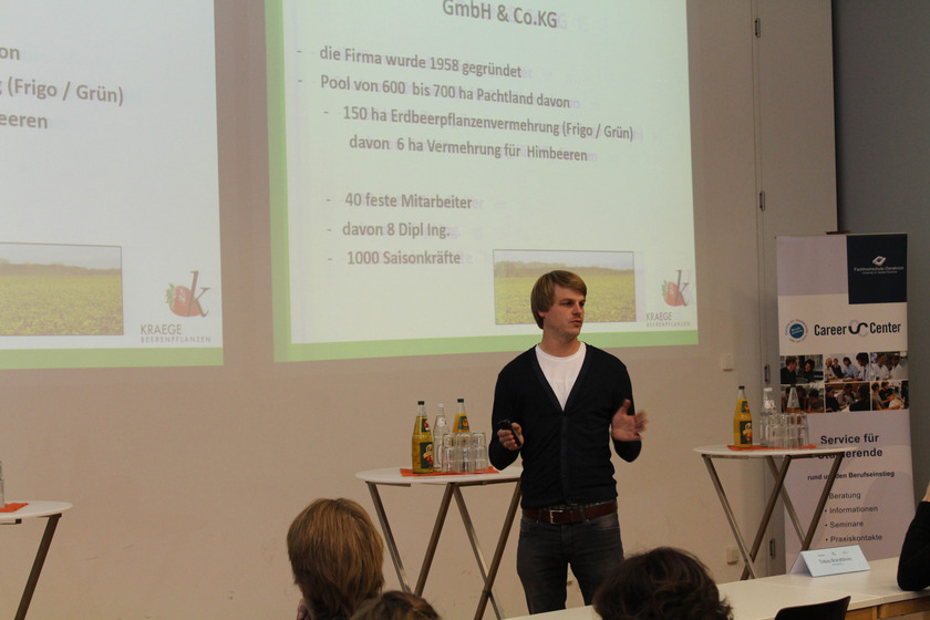 Präsentation Das Bild zeigt einen jungen Mann vor einer Leinwand.