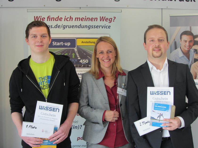 Drei Personen, zwei mit Urkunden in der Hand.
