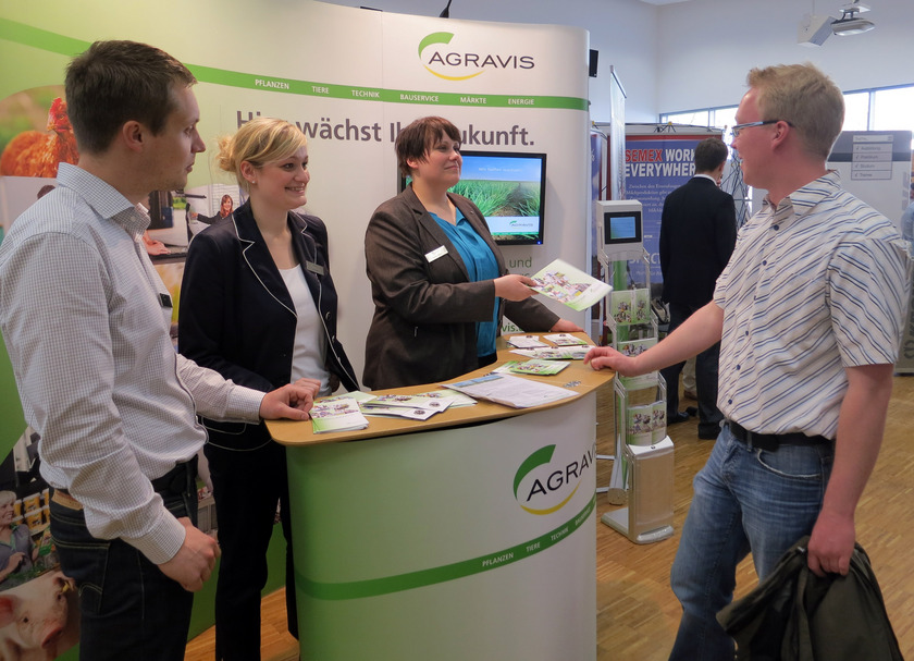 Man sieht vier Personen an einem Informationsstand stehen.
