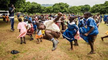 Tanzende Kinder in Uganda, die im Zuge des Projekts Viva con Agua Uganda über Fragen zur Trinkwasserversorgung, sanitären Anlagen und Hygiene aufgeklärt werden