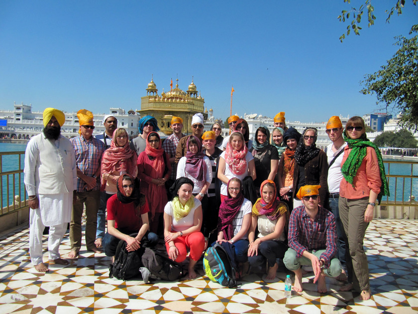 Auf dem Bild sieht man, eine Gruppe von jungen Leuten vor einem goldenen Tempel stehen.