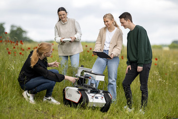Landtechnik: Vier Studierende mit einem Feldroboter