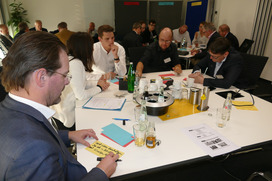 Die Workshop-TeilnehmerInnen diskutieren an insgesamt drei Thementischen und schreiben Ihre Ideen und Ergebnisse auf Karten, die im Anschluss an eine Pinwand geheftet und vorgestellt werden.