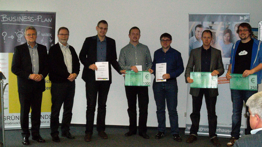 Das Bild zeugt eine Gruppe von sieben Personen. Einige haben Gutscheine mit Geldpreisen in der Hand.