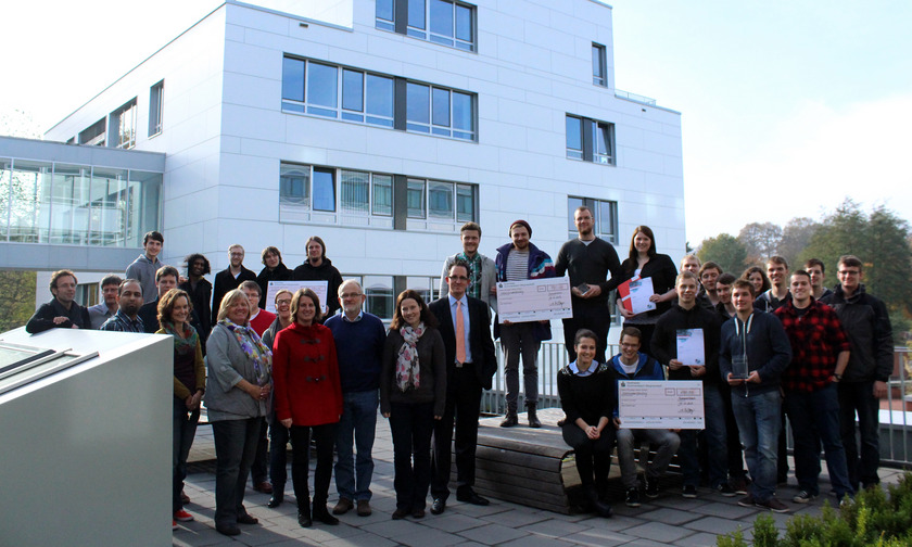 Drei Gruppen halten Schecks in der Hand.
