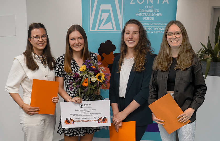 Vier junge Frauen lächeln in die Kamera