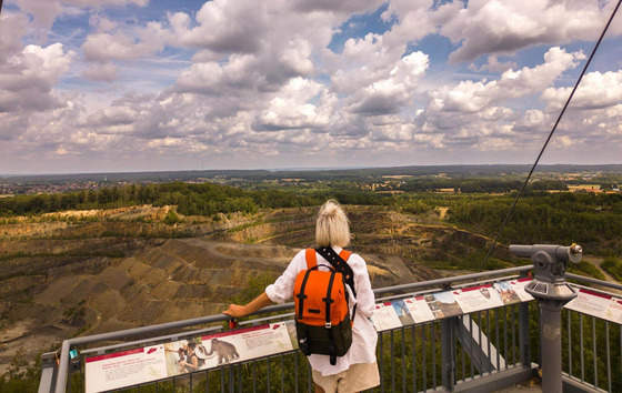 Die Region Osnabrück hat viele Wandertipps zu bieten. Dazu gehört auch der Piesberg auf dem eine Frau mit einem orangenen Rucksack in den Nordkreis schaut. 