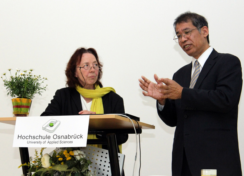 Das Bild zeigt eine Frau und einen Mann am Rednerpult.