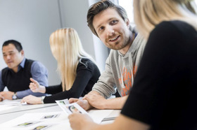 Vier Studierende bei der Bearbeitung einer Werbebotschaft