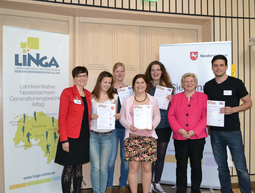 Das Bild zeigt fünf Studierende und zwei Frauen, die vor RollUps mit dem Schriftzug LINGA stehen und Urkunden in den Händen halten.