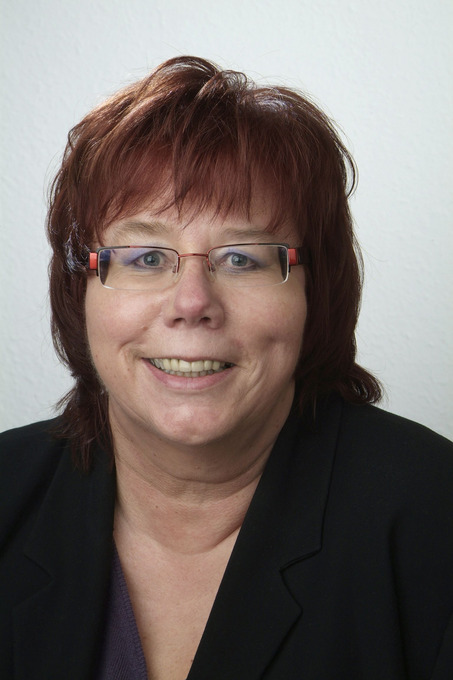 Man sieht das Portrait einer Frau mit kurzen Haaren.