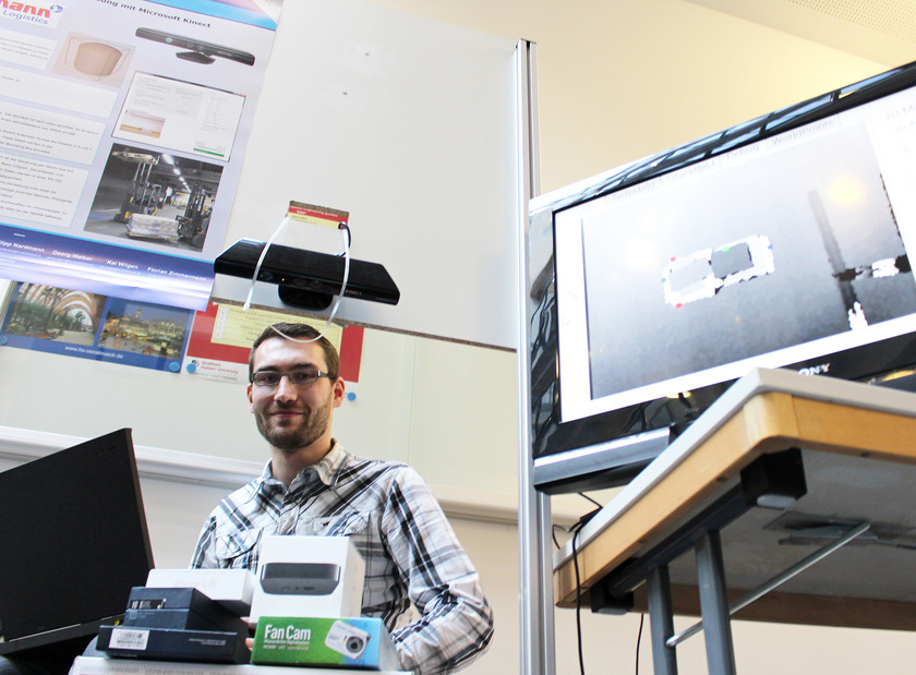 Ein Mann sitzt neben einem Fernseher.