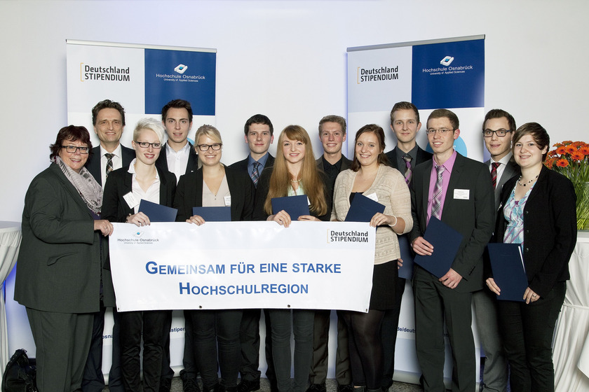 Man sieht junge Menschen mit einem Plakat in der Hand.