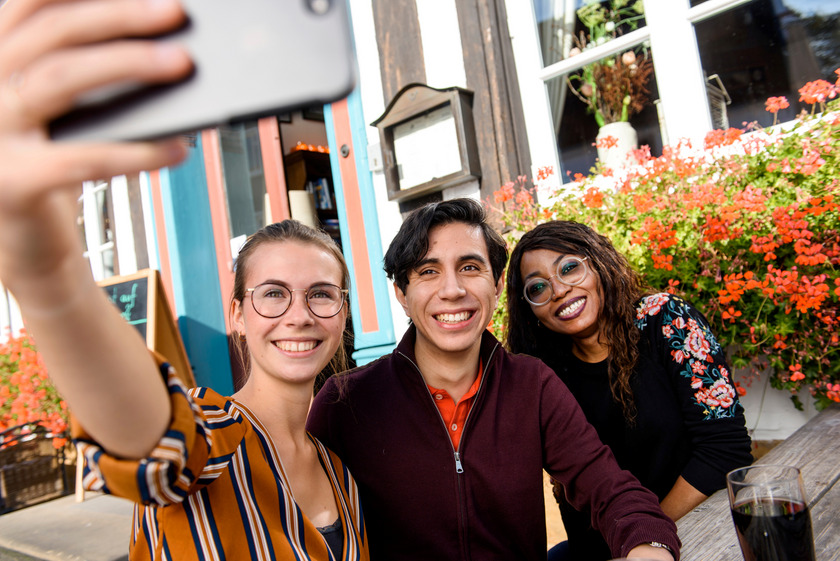 Drei Menschen mit unterschiedlicher Herkunft, die ein Selfie mit einem Handy machen