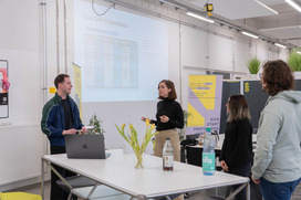 Vier Personen stehen in einem Workshopraum und haben ein Gruppencoaching