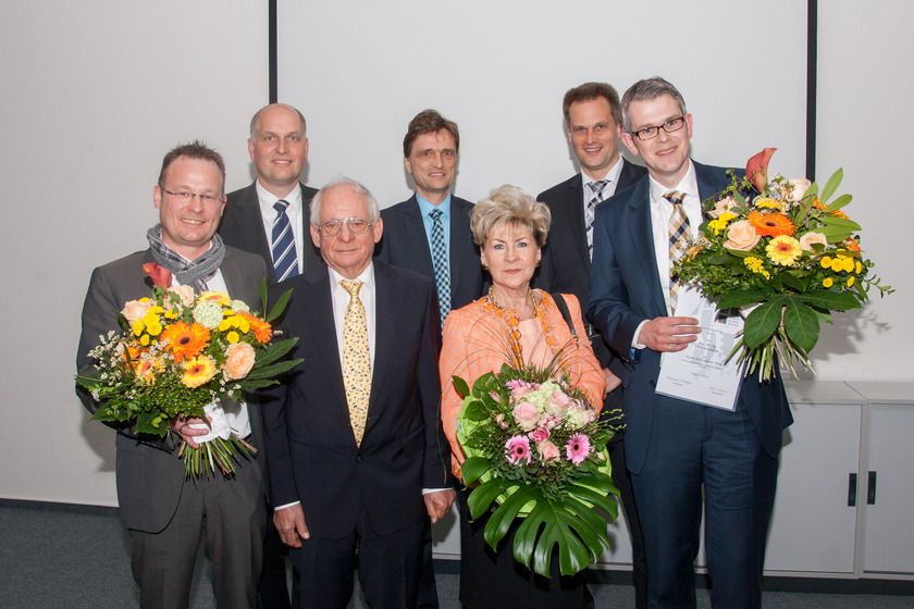 Sieben Personen halten Blumensträuße in der Hand.