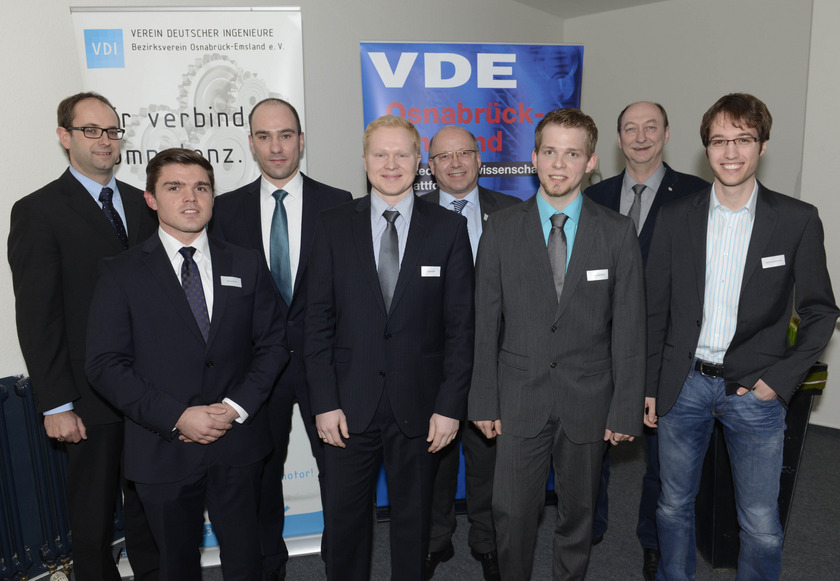 Man sieht acht Männer in dunklen Anzügen.