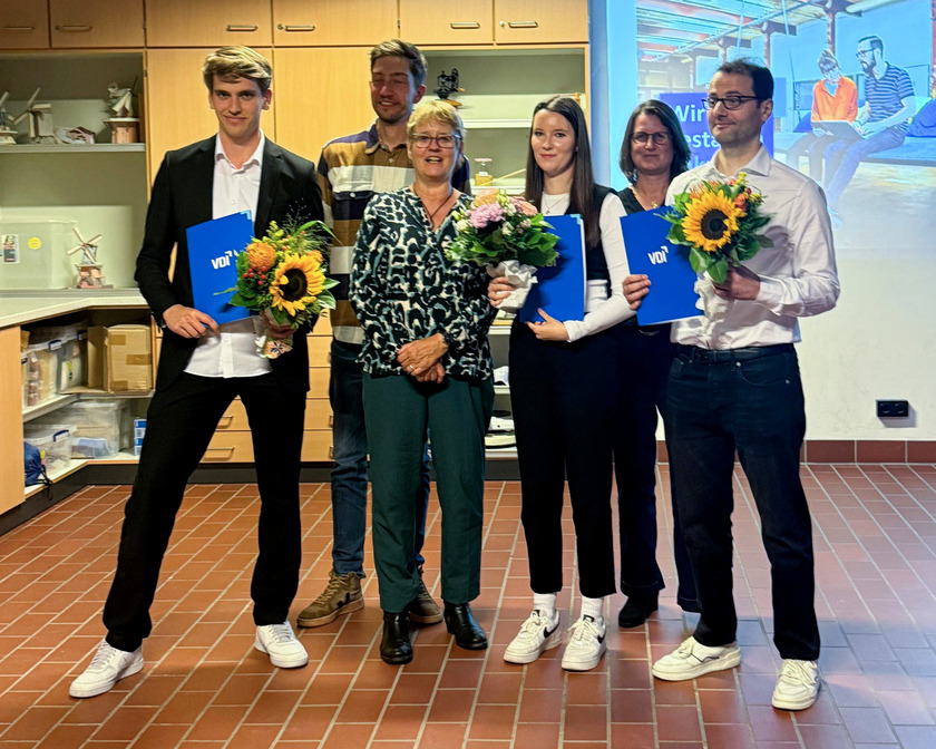 Drei Studierende und ihre Betreuer*innen lächeln in die Kamera.