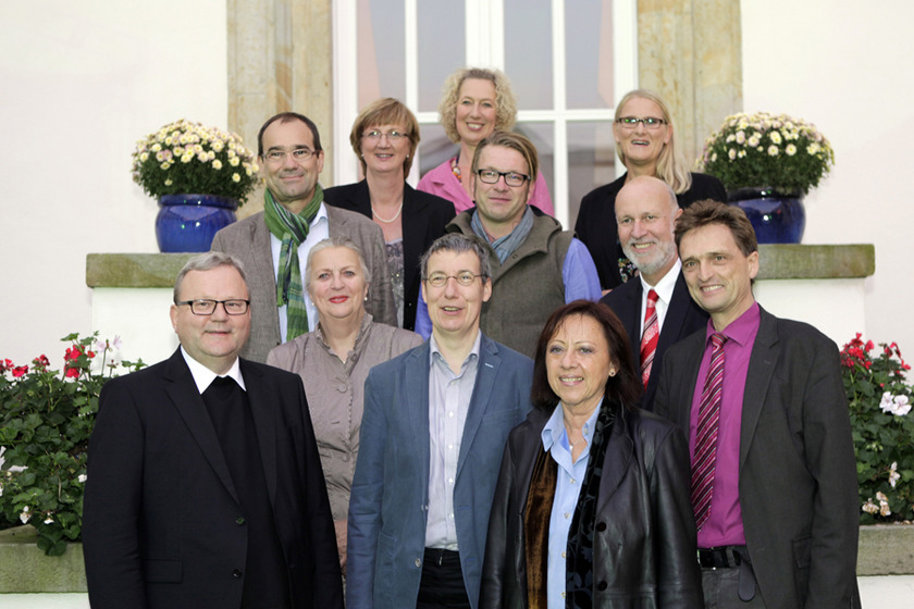 Eine Gruppe von elf Personen steht auf einer Treppe.