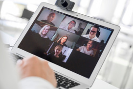 Das Bild zeigt einen Laptop-Bildschirm, auf dem sieben Personen in einer Videokonferenz miteinander reden.
