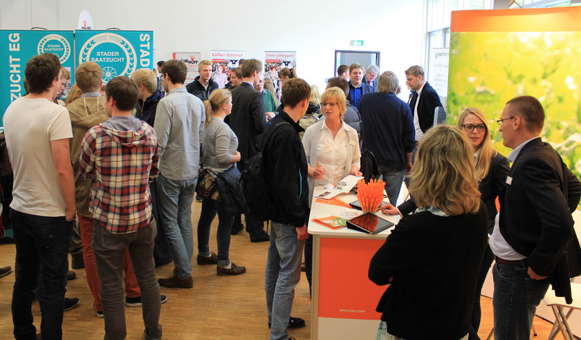 Blick auf die gut besuchte Messe mit Besuchern und Ständen.