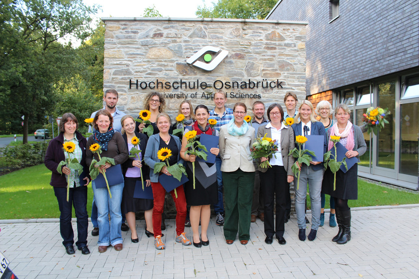 Das Bild zeigt viele Menschen mit Sonnenblumen in der Hand.