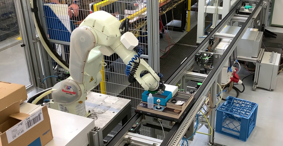 Das Bild zeigt einen Roboterarm, der den Griff mit der Druckplatte des Stempels verbindet.