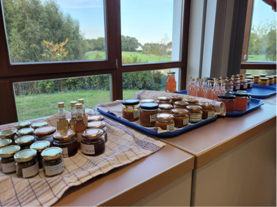 Ein Tisch voller Einmachgläser mit Marmeladen und Ketchup.