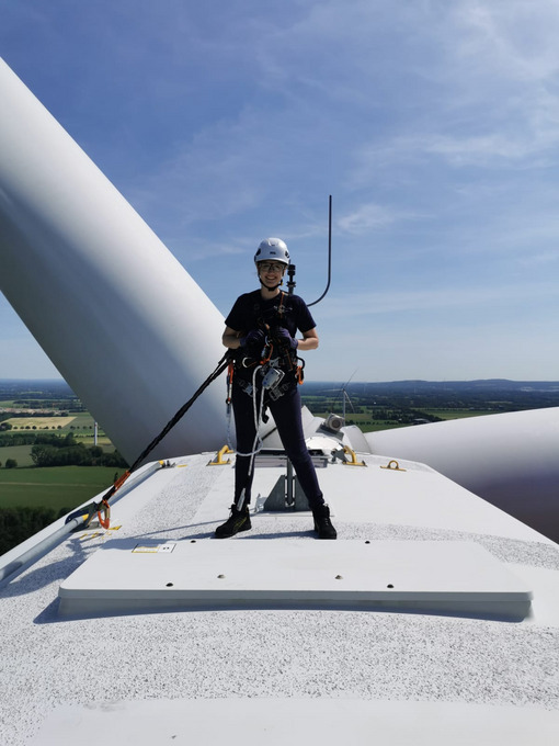 Anna Lena Schmitz steht auf einer Windkraftanlage.