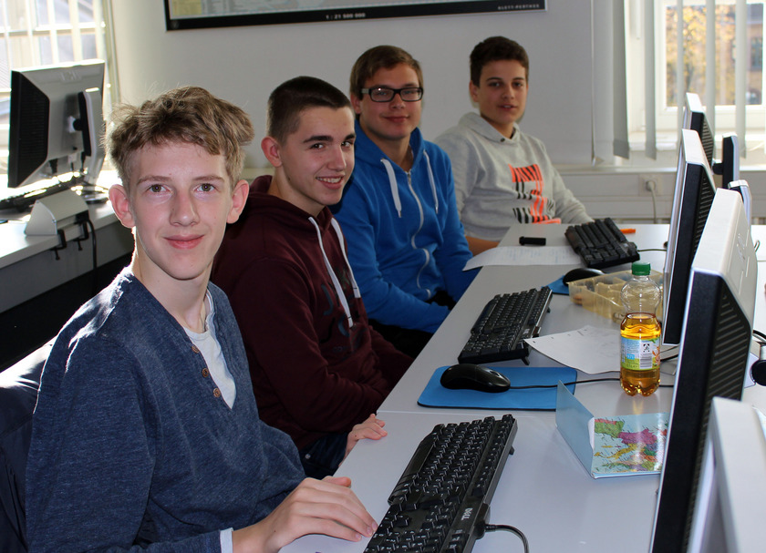 Vier Jungs sitzen vor Computern.