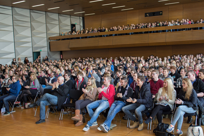 Das Bild zeigt viele Menschen in der Aula applaudieren.