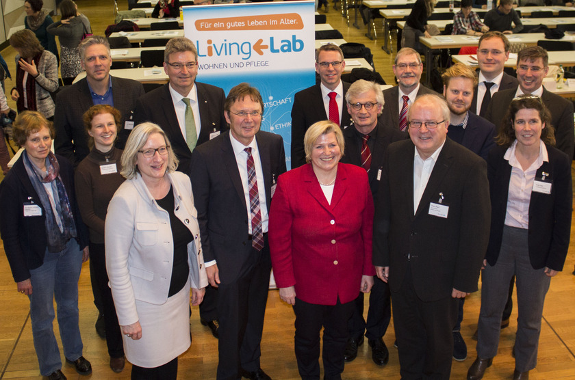 Das Bild zeigt eine große Gruppe von Menschen in einem großen Saal.