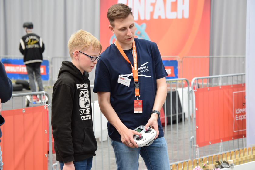Student und Schüler lenken gemensam einen Roboter.