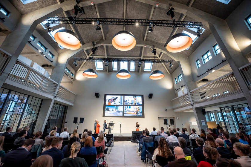 Das Bild zeigt eine Veranstaltung im Coppenrath Innovation Centre, bei der viele Menschen auf Stühlen sitzen und einem Vortrag zuhören. 