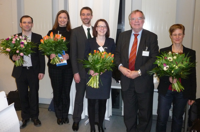 Auf dem Bild sieht man sechs Personen, drei davon haben Blumensträuße in der Hand.