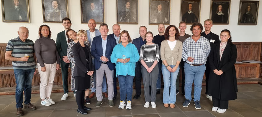 Die gruppe der Workshopteilnehmer*innen stehen im Rathaus. 