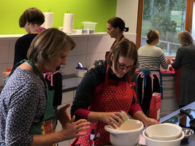 Mehrere Frauen in der Aktionsküche des WABE-Zentrums bei der Zubereitung von Speisen.