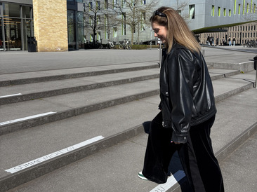 Studentin geht auf die auf dem Boden markierte Antwortoption