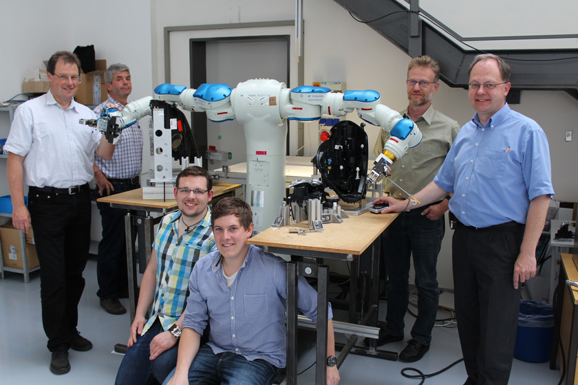 Die Vertreter der Hochschule Osnabrück und der Firma HELLA schauten sich die Präzisionarbeit des 15-achsigen Roboters an.
