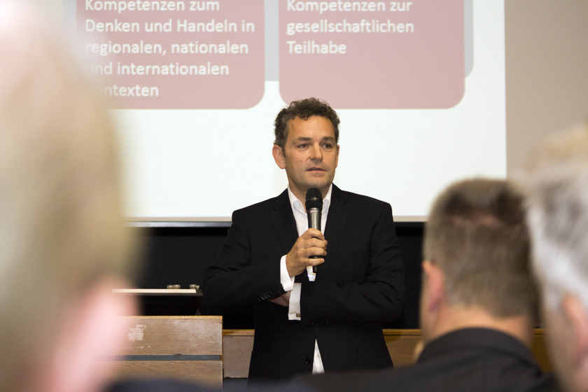 Das Bild zeigt einen Mann mit einem Mikro in der Hand.